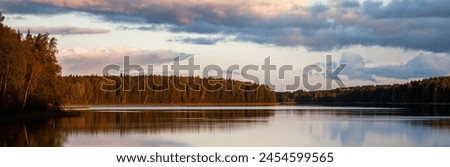 Sunrise on the lake. Clouds over the water in the early morning in the light of the sun. View of lake in the early morning in autumn