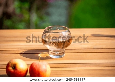 Brut apple cider from Betuwe, Gelderland, in glass on wooden table, apple cider production in Netherlands Royalty-Free Stock Photo #2454599997