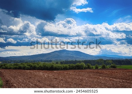 View with mountain and farmland and sky.