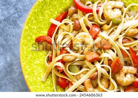 Close up, top view, overhead, above, flat lay. Food photography. Seafood pasta, shrimp, fettucine noodles, red peppers, onions, carrots, celery, cashews, almonds, olive oil, soya sauce. Delicious.