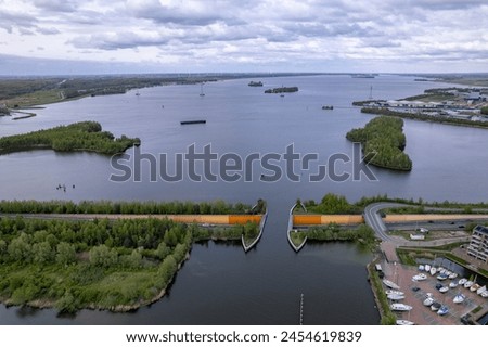 Veluwemeer aerial landscape with aquaduct seen from above. Dutch waterway infrastructure for boats to pass over freeway with traffic passing by