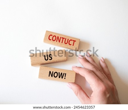 Contact us now symbol. Wooden blocks with words Contact us now. Beautiful white background. Businessman hand. Business and Contact us now concept. Copy space.