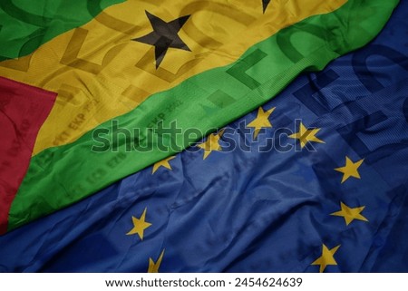 waving colorful flag of european union and flag of sao tome and principe on a euro money banknotes background. finance concept. macro Royalty-Free Stock Photo #2454624639