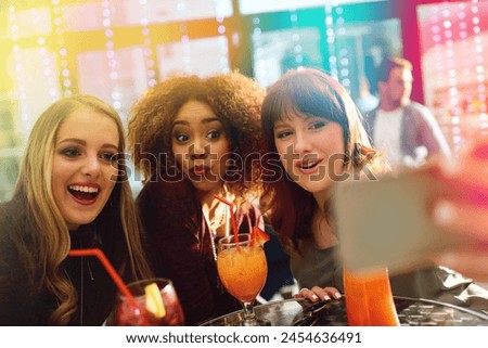 Woman, friends and drinks or party selfie, diversity and fun with alcohol or cocktails in club for entertainment. Smartphone, happy and online for social media post, technology and celebration