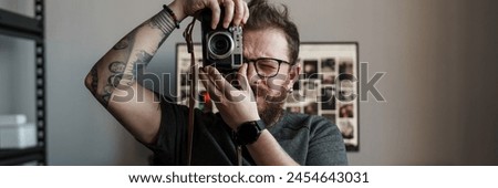 A creative photographer focuses a vintage camera, capturing unique moments against a backdrop of photo frames.