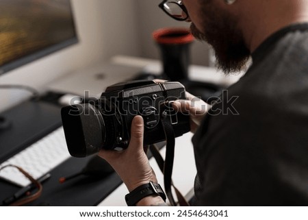 Close-up of a photographer's hands adjusting a medium format camera, highlighting intricate details and the art of photography.