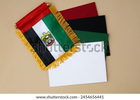 Colorful envelopes template sample National symbol of UAE. United Arab Emirates small flag with Peregrine falcon on neutral beige background. Copy space for your text. Concept of Independence  Royalty-Free Stock Photo #2454656441