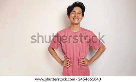 Handsome young Asian man is happy, cheerful and enthusiastic posing coolly with an isolated white background. wearing a red shirt Royalty-Free Stock Photo #2454661843