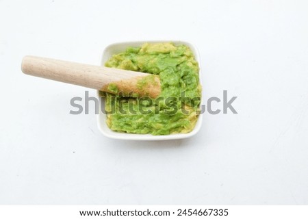Baby food 
fresh green Avocado mashed in a small ceramic bowl isolated on a white backdrop.
Healthy baby food, vegetables, and fruit ideas.