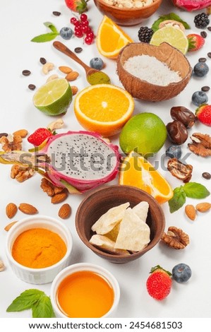 Assorted fresh fruits and nuts on a white background. Ingredients for a healthy dish. Superfoods and antioxidants