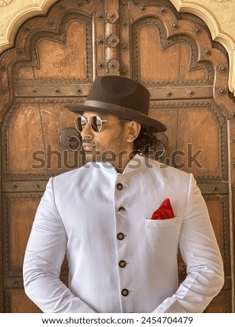 graceful man showcases cultural elegance in traditional attire, exuding confidence and heritage in a single pose Royalty-Free Stock Photo #2454704479