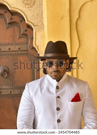 graceful man showcases cultural elegance in traditional attire, exuding confidence and heritage in a single pose Royalty-Free Stock Photo #2454704485