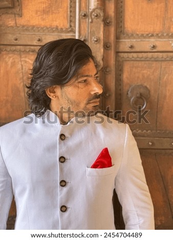 graceful man showcases cultural elegance in traditional attire, exuding confidence and heritage in a single pose Royalty-Free Stock Photo #2454704489