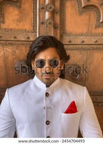 graceful man showcases cultural elegance in traditional attire, exuding confidence and heritage in a single pose Royalty-Free Stock Photo #2454704493