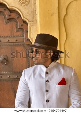 graceful man showcases cultural elegance in traditional attire, exuding confidence and heritage in a single pose Royalty-Free Stock Photo #2454704497