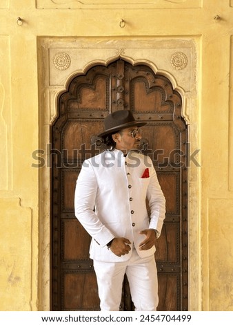 graceful man showcases cultural elegance in traditional attire, exuding confidence and heritage in a single pose Royalty-Free Stock Photo #2454704499