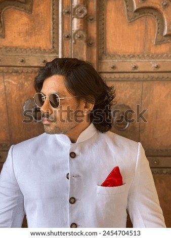 graceful man showcases cultural elegance in traditional attire, exuding confidence and heritage in a single pose Royalty-Free Stock Photo #2454704513