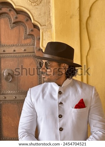 graceful man showcases cultural elegance in traditional attire, exuding confidence and heritage in a single pose Royalty-Free Stock Photo #2454704521