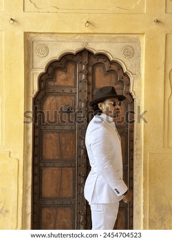 graceful man showcases cultural elegance in traditional attire, exuding confidence and heritage in a single pose Royalty-Free Stock Photo #2454704523