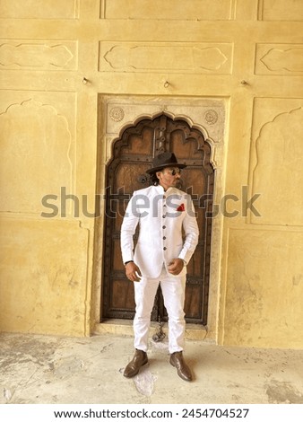 graceful man showcases cultural elegance in traditional attire, exuding confidence and heritage in a single pose Royalty-Free Stock Photo #2454704527