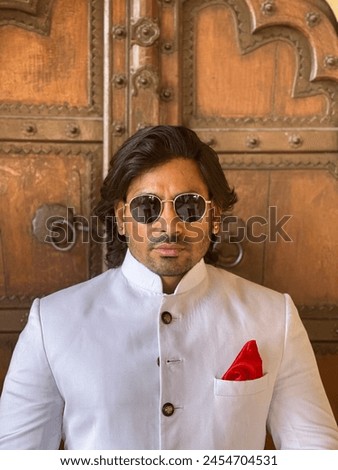graceful man showcases cultural elegance in traditional attire, exuding confidence and heritage in a single pose Royalty-Free Stock Photo #2454704531