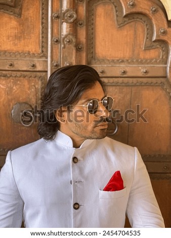 graceful man showcases cultural elegance in traditional attire, exuding confidence and heritage in a single pose Royalty-Free Stock Photo #2454704535