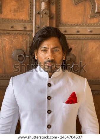 graceful man showcases cultural elegance in traditional attire, exuding confidence and heritage in a single pose Royalty-Free Stock Photo #2454704537