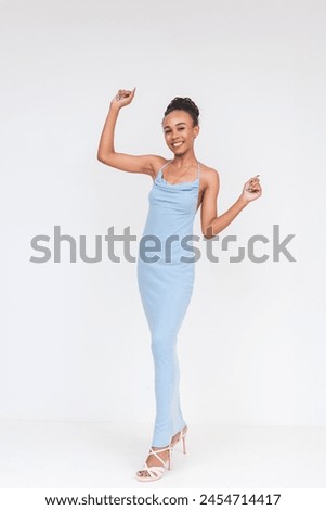 Animated image of a young woman with a mixed heritage looking lively and happy while dancing in a blue dress against a white backdrop.