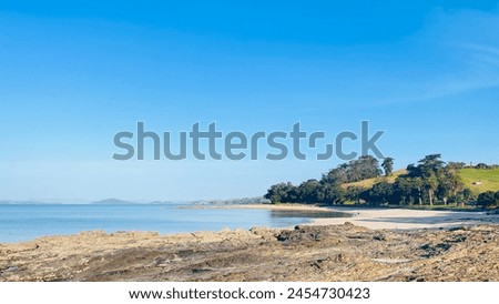 In a harmonious picture, there are mountains, water, coast and beach, and the sky is blue and white clouds are fluttering across the sea.