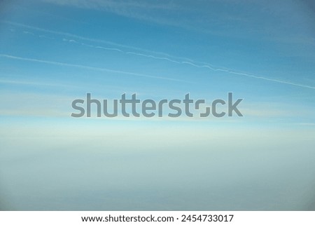 This is a blue sky and white clouds shot through the hanging window of an airplane.