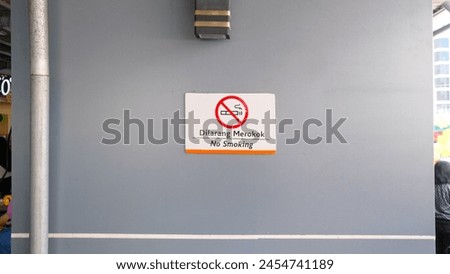 A photo of a no-smoking sign in the waiting area of a train station.