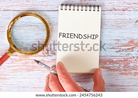 FRIENDSHIP TEXT a man's hand takes a notebook with the inscription
