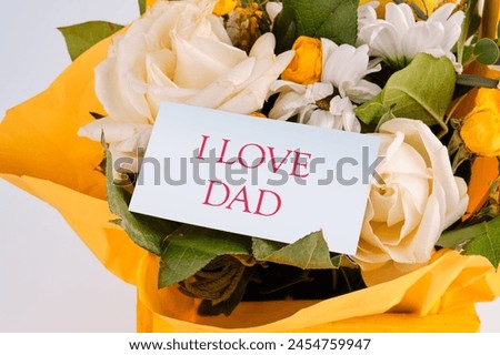 Happy fathers day, i love dad on a business card in a bouquet of flowers