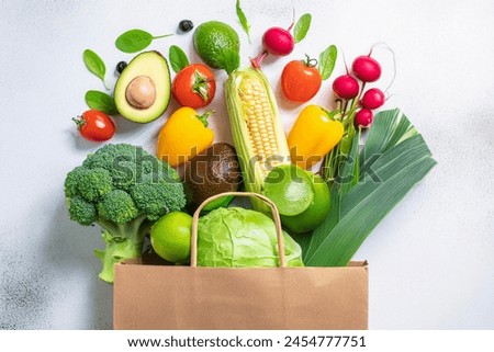 Clean eating concept: a supermarket haul of vegan-friendly produce in a paper bag.