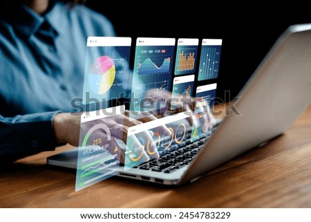 Businesswomen analyze chart data business on a visual screen dashboard laptop, technology devices and screens visible in the background, financial planning, market research, and the stock market.