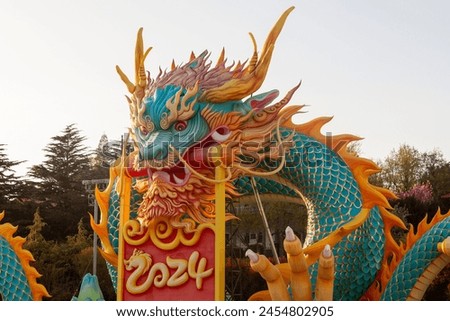 Multi-colored figure of a Chinese dragon with a scroll in its mouth.