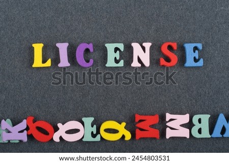 LICENSE word on black board background composed from colorful abc alphabet block wooden letters, copy space for ad text. Learning english concept