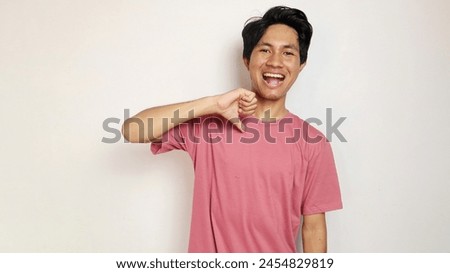 Handsome young Asian man is happy, cheerful and enthusiastic posing coolly with an isolated white background. wearing a red shirt Royalty-Free Stock Photo #2454829819