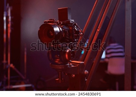 Closeup background image of digital video camera set up on rig in studio with neon lights copy space