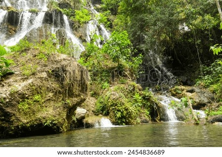 MAJESTIC WATERFALL WITH CLEAR SKY AND FOREST