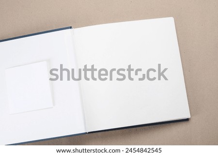 One open photo album on color background, top view. Space for text