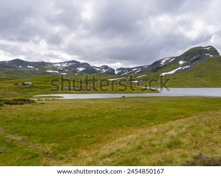 A panoramic view of Vikafjell in Norway. The road from Vik to Vinje. Road number 13. Vikafjell is a mountain range in western Norway. In the background there is still snow on the mountains in summer