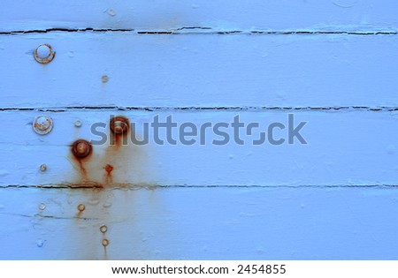 Weathered blue-painted timber, with rusted bolts.