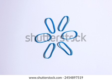 blue vibrant colored mini rubber band isolated on white background forming a hexagon shape look alike, conceptual photo illustration Royalty-Free Stock Photo #2454897519