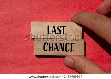 Last chance words written on wooden blocks with red background. Conceptual last chance symbol. Copy space.