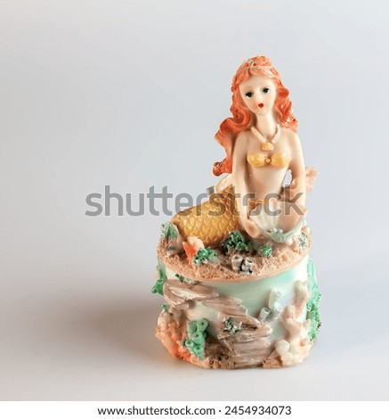Mermaid figurine on a white background. Fairytale character. Toy mermaid. Feminine appearance.