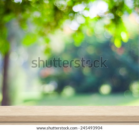 Green nature background, Empty wooden deck table over blur tree garden park with bokeh in spring summer outdoor background, Wood shelf, counter, desk surface for food picnic, product display montage