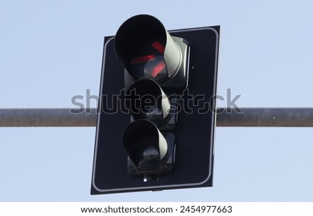 Red traffic light with arrow to turn right attached to an arm Royalty-Free Stock Photo #2454977663