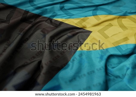 waving colorful national flag of bahamas on a euro money banknotes background. finance concept. macro shot