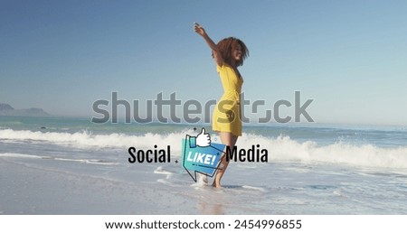 Image of social media and like icon over happy african american woman having fun on beach. Holidays, vacations, social media and technology concept digitally generated image.